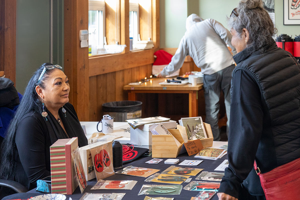 Una-Ann speaks with a guest at the 2025 Student Holiday Card Sale